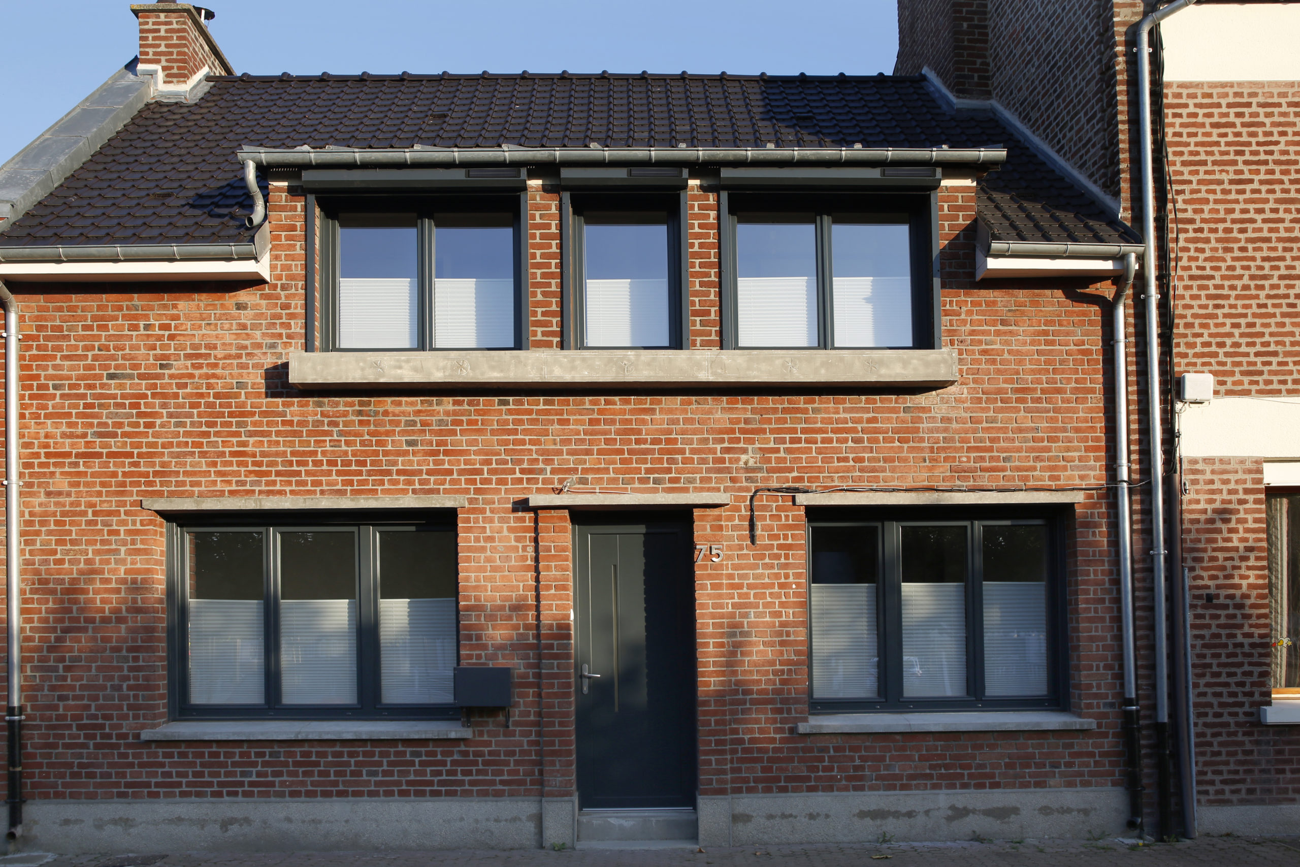 maison en brique équipée de volets roulants solaires